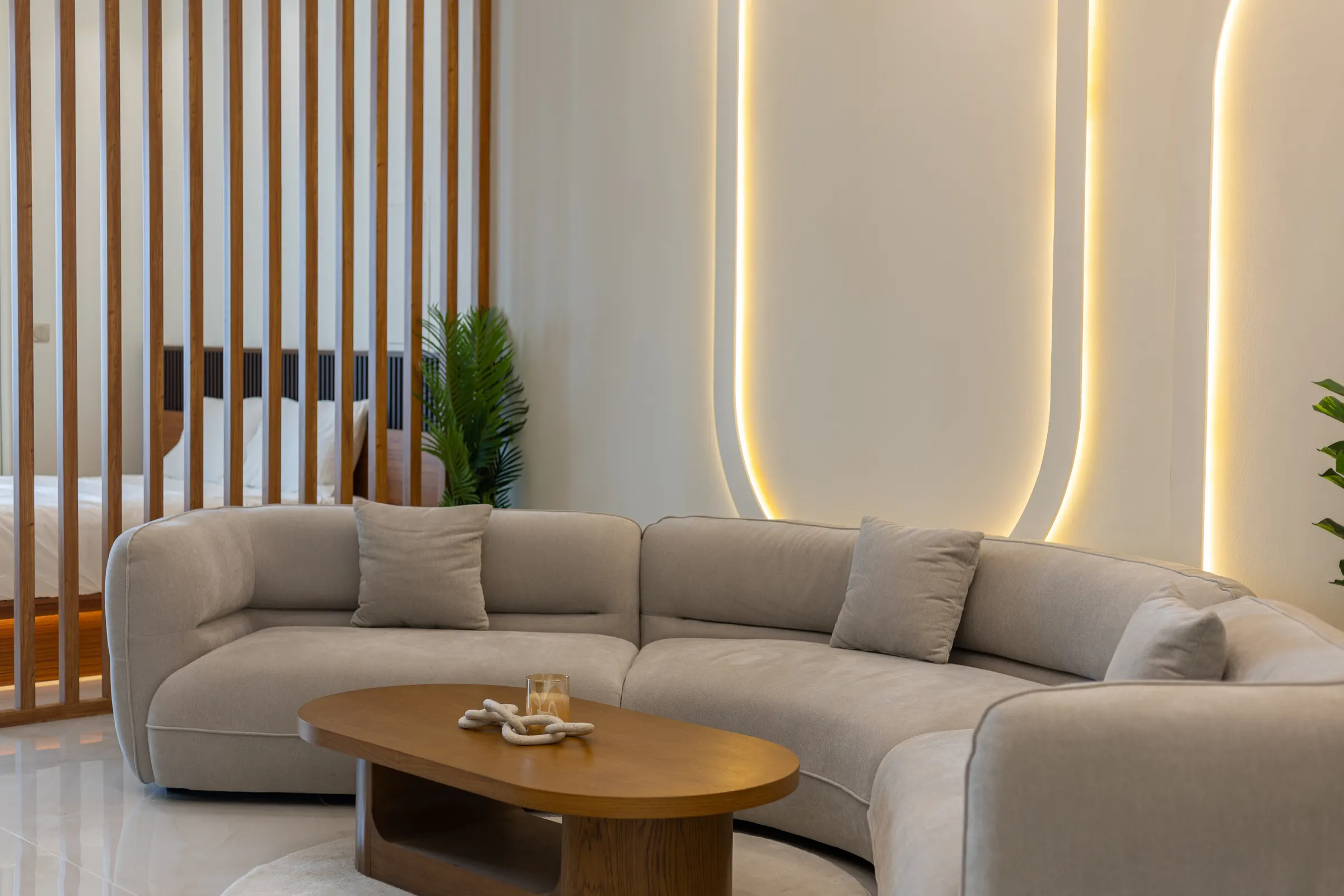 Curved cream sectional under a warm light cove — DEC Tower, Dubai Marina