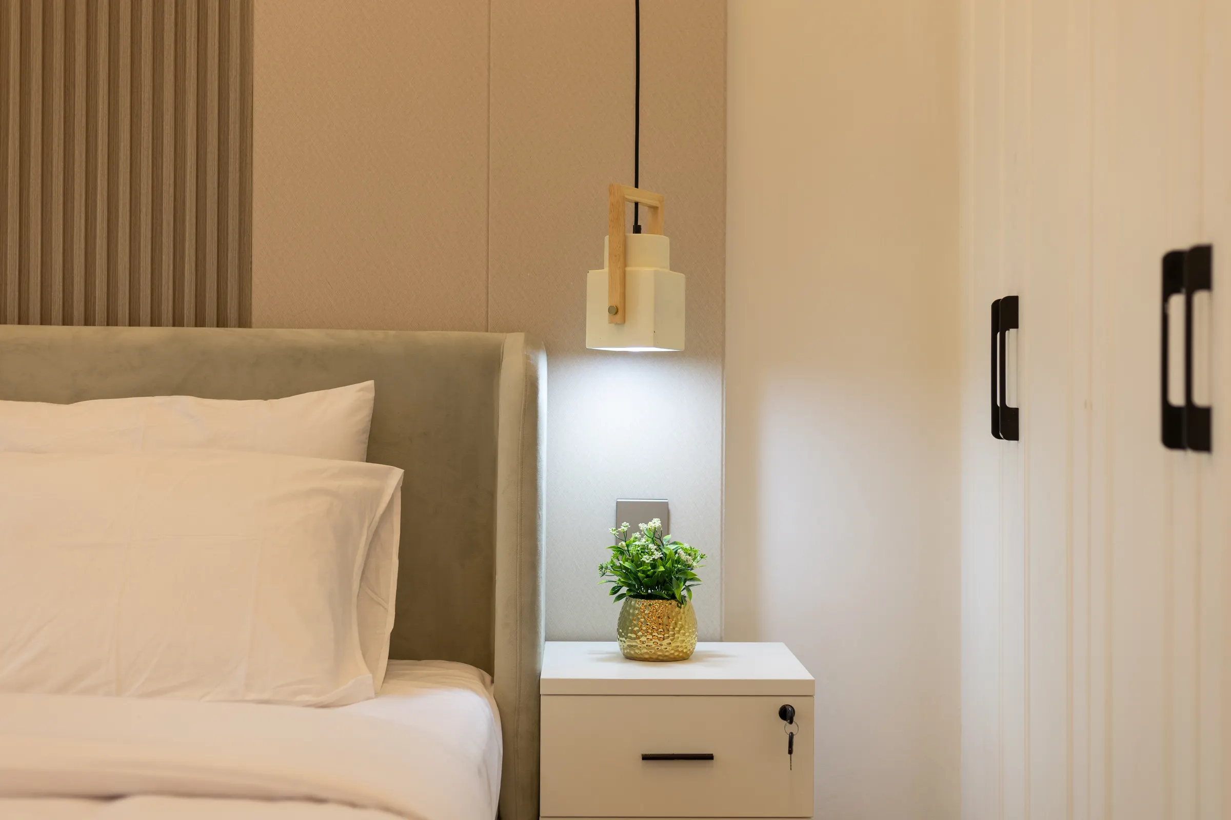 Made bed and pendant lamp in a Manchester Tower apartment, Dubai Marina